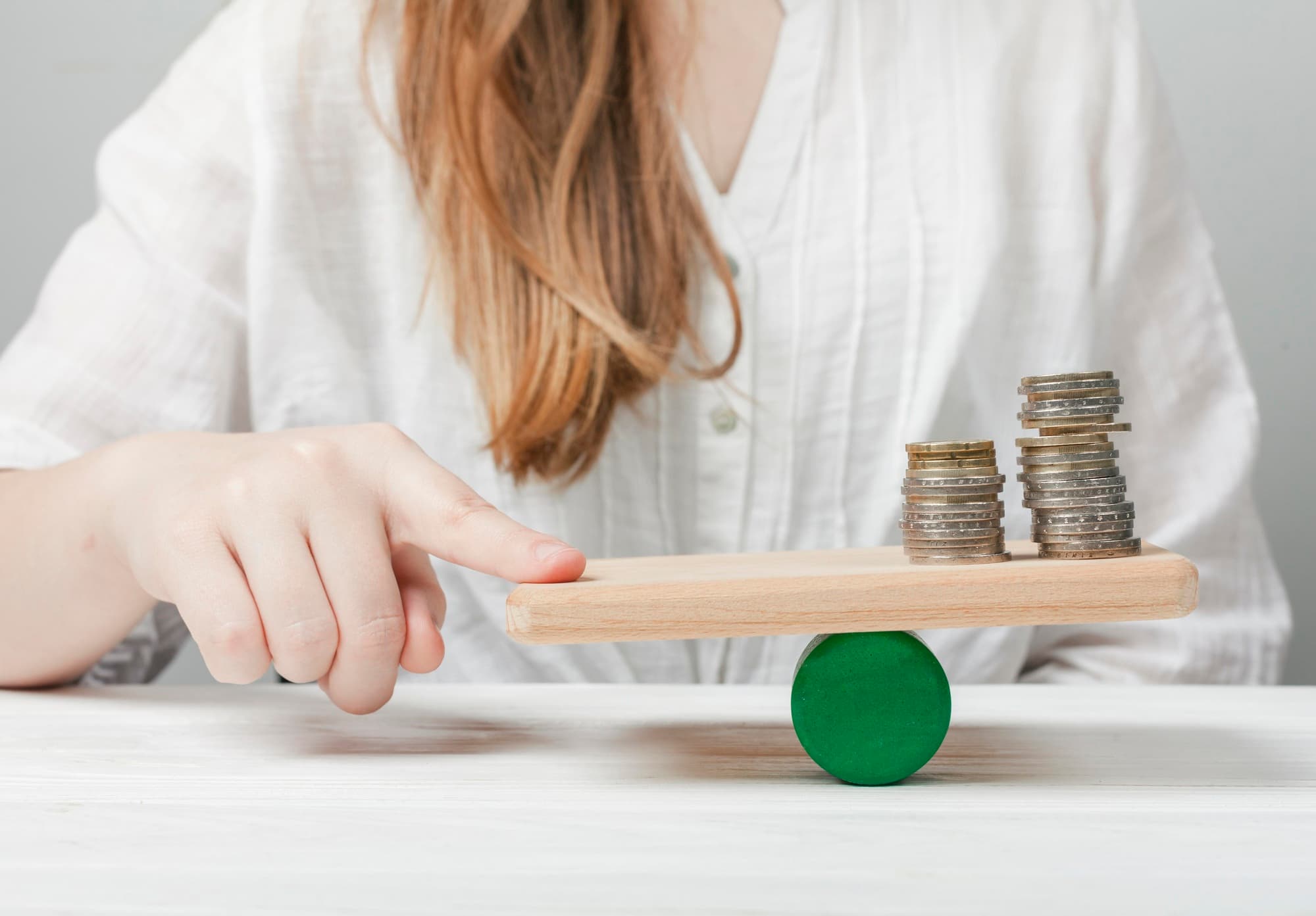 Woman holding her finger balance with coins